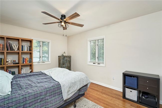 Bedroom featuring multiple windows, wood finished floors, baseboards, and a ceiling fan | Image 20