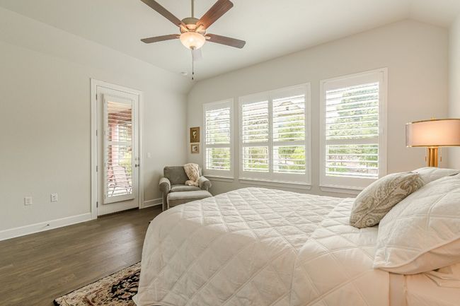 Bedroom with access to exterior, multiple windows, baseboards, dark wood finished floors, and lofted ceiling | Image 28