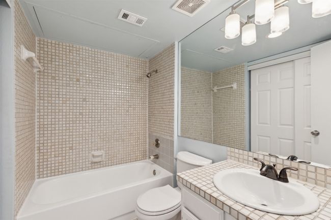downstairs Full bath featuring shower / washtub combination, visible vents, vanity, and toilet | Image 14