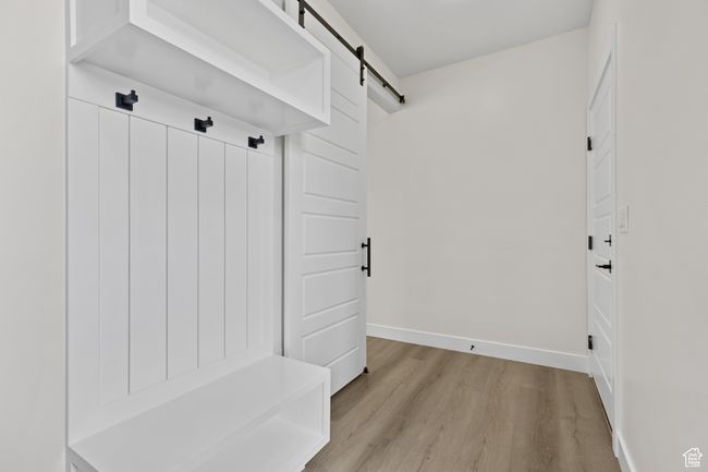 Mudroom featuring light wood finished floors, baseboards, and a barn door | Image 24