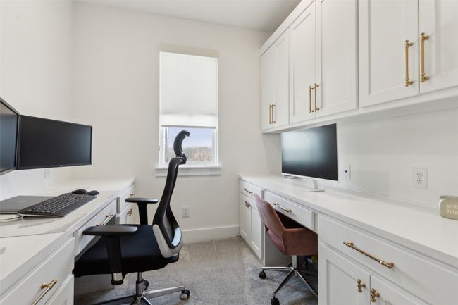 Home office with built in desk, light colored carpet, and baseboards | Image 32