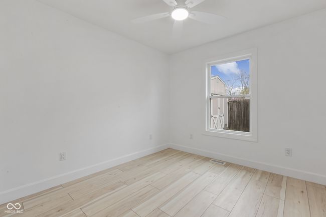 spare room with wood finished floors, ceiling fan, baseboards, and visible vents | Image 50