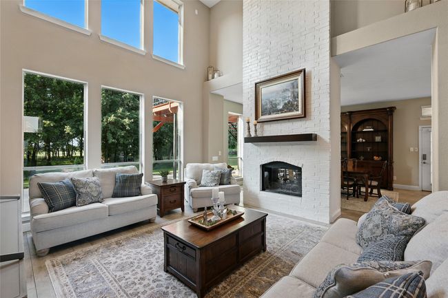 Living room featuring a high ceiling and a see through fireplace | Image 8