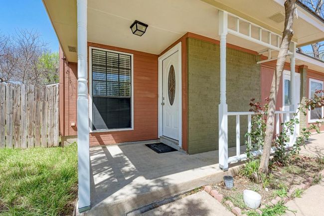 Entrance to property featuring brick siding, a porch, and fence | Image 7