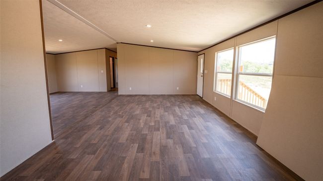 Empty room with dark wood finished floors, a textured ceiling, lofted ceiling, and recessed lighting | Image 8