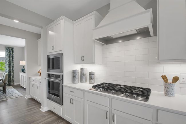Gourmet kitchen with cooktop, wood hood, wall microwave and oven. Imagine cooking here! Model photo. Options and colors will vary. | Image 5