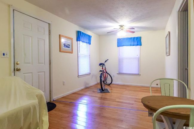Exercise area featuring light wood finished floors, a ceiling fan, and a textured ceiling | Image 5