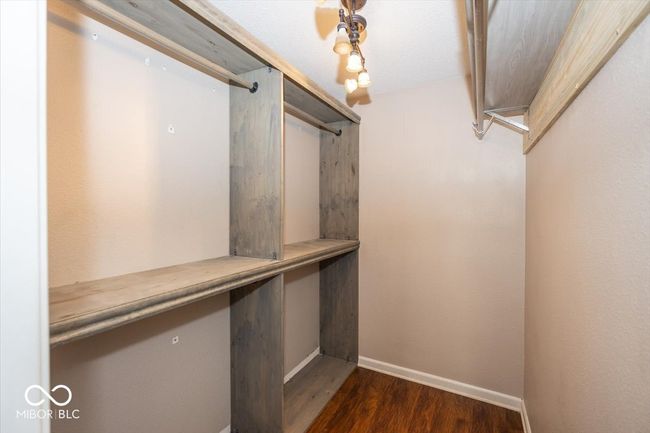 spacious closet featuring dark wood-type flooring | Image 19