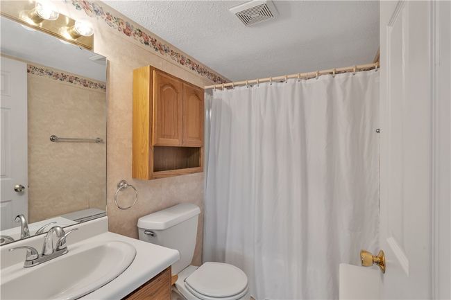 Main Floor Primary Bedroom en Suite Bath with Oak Vanity and Storage Above Toilet, Fiberglass Tub/Shower. | Image 21