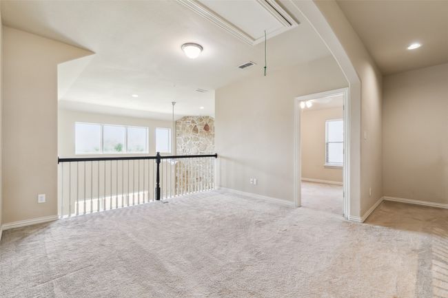 Empty room with attic access, carpet flooring, plenty of natural light, and arched walkways | Image 29