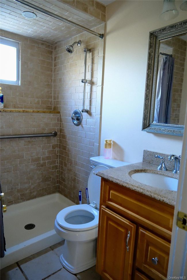 1st floor Full bath featuring vanity, a stall shower, and tile patterned floors | Image 22