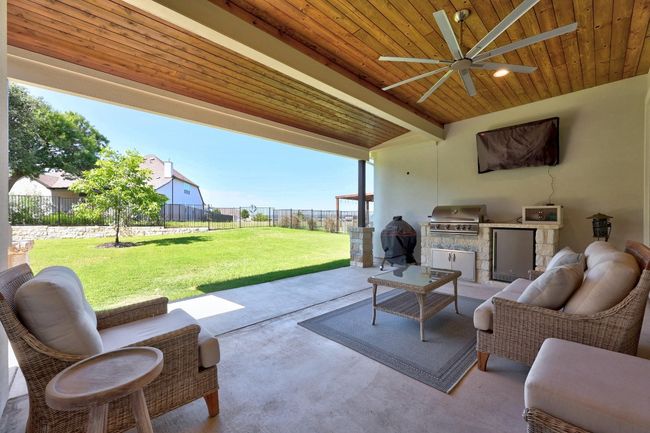 State-of-the-art outdoor kitchen includes a natural gas grill, a built-in mini fridge, and generous countertop space that makes prep effortless. | Image 37