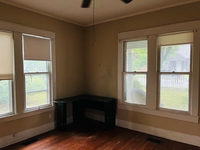 Unfurnished room featuring healthy amount of natural light, dark wood finished floors, ornamental molding, baseboards, and a ceiling fan | Image 9