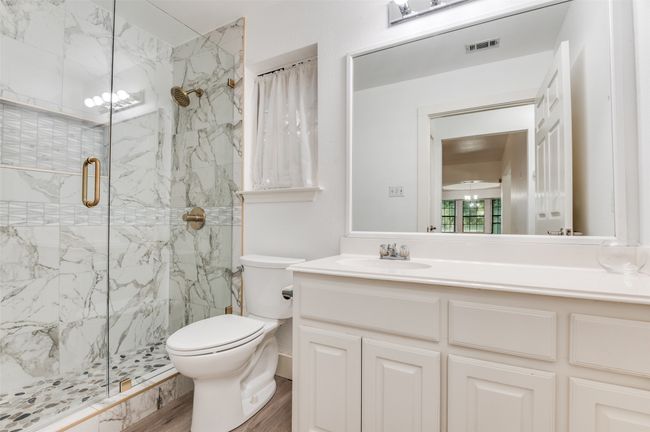 Full bath with a marble finish shower, vanity, and wood finished floors | Image 21