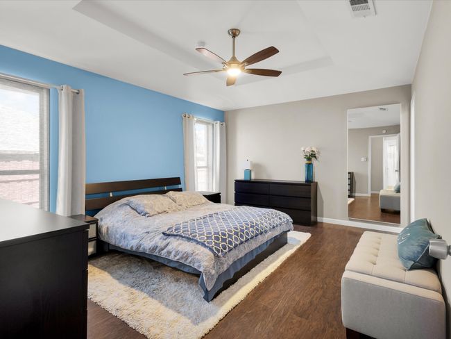Bedroom with a tray ceiling, dark wood-style floors, and a ceiling fan | Image 14