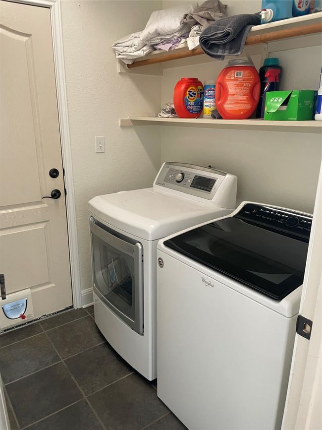 Laundry area featuring separate washer and dryer and dark tile patterned flooring | Image 23