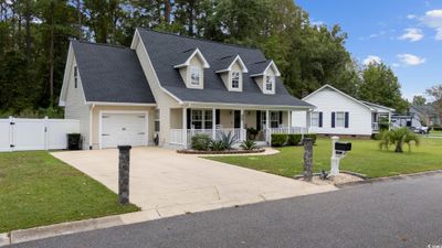 New england style home with covered porch and a front yard | Image 3