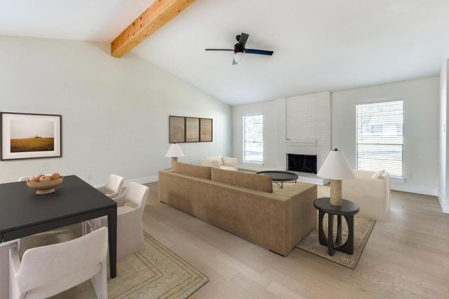 Living area with a fireplace, a wealth of natural light, a ceiling fan, and light wood finished floors | Image 5