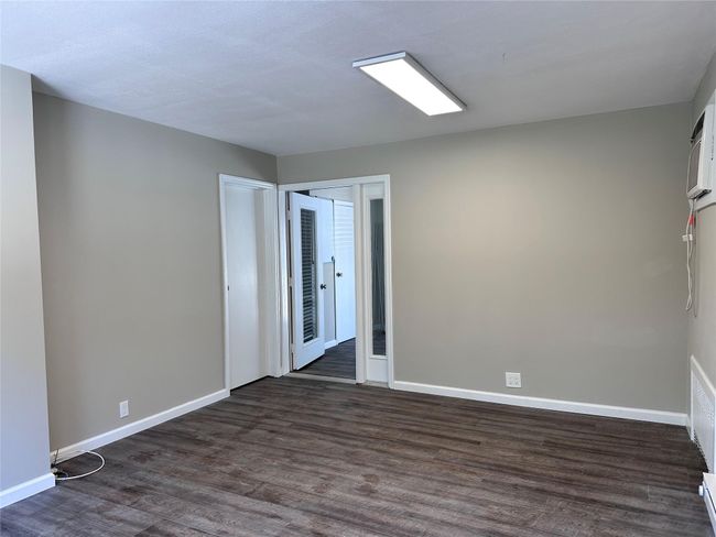 Spare room with baseboards and dark wood-style flooring | Image 27