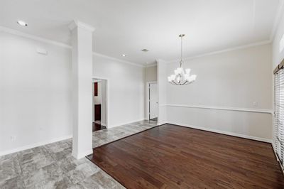 Dining area view to kitchen area with nice wood flooring. | Image 3