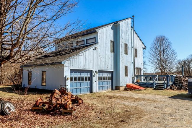 Enjoy a large attached garage with a high ceiling and a concrete floor. | Image 10