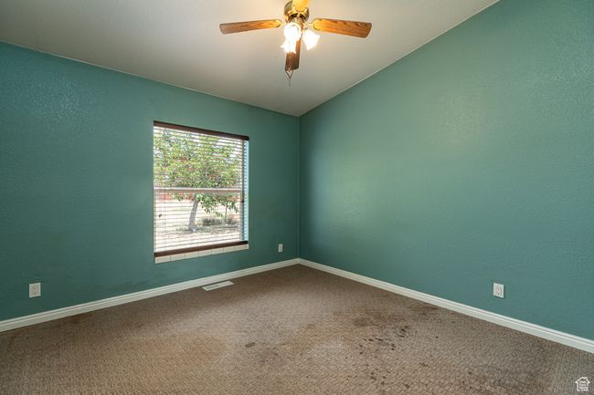 Carpeted empty room with vaulted ceiling and ceiling fan | Image 19