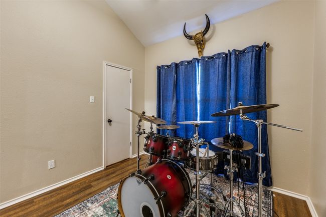 Recreation room featuring vaulted ceiling, wood finished floors, and baseboards | Image 19