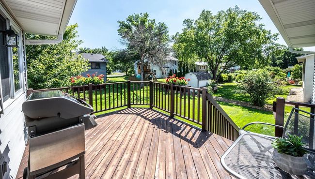 Custom deck with built-in flower boxes, & stairs to playful flat backyard. | Image 15