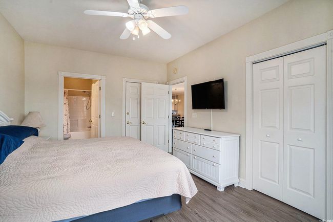 Bedroom with wood finished floors, ensuite bath, a ceiling fan, and baseboards | Image 9