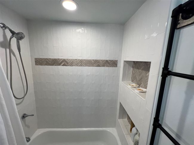 Full tub with detachable handheld shower, plenty of towel rack space | Image 15