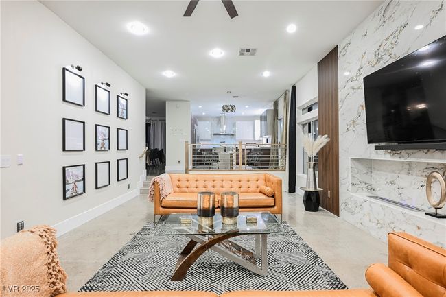 Living area with concrete flooring, ceiling fan, visible vents, and recessed lighting | Image 22