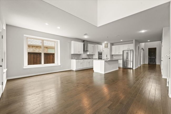 Unfurnished living room featuring dark wood-type flooring, a sink, baseboards, and recessed lighting | Image 13
