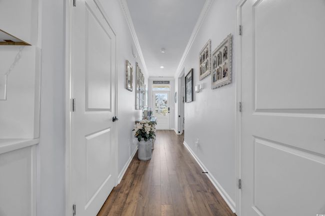 Hall featuring crown molding, dark wood-type flooring, and baseboards | Image 6