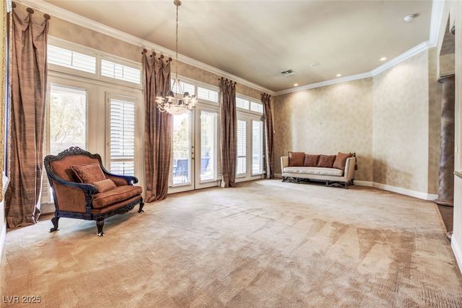 Living area featuring an inviting chandelier, ornamental molding, carpet flooring, visible vents, and french doors | Image 10