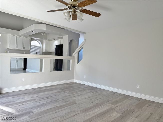 Unfurnished living room featuring light wood-style flooring, arched walkways, baseboards, and ceiling fan | Image 22