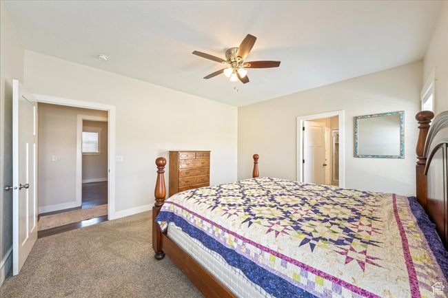 Carpeted bedroom featuring baseboards, a ceiling fan, and multiple windows | Image 21