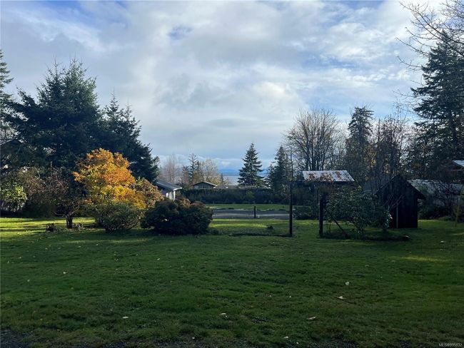 looking toward two sheds on property and intended building site, currently has a level full hookup RV pad in place | Image 8