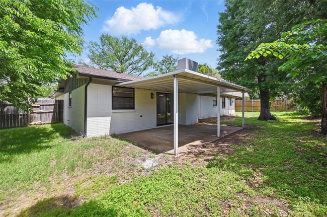 Rear view of property with brick siding, a chimney, a patio, and a carport | Image 17