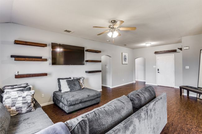 Living room featuring ceiling fan and dark hardwood / wood-style flooring | Image 5
