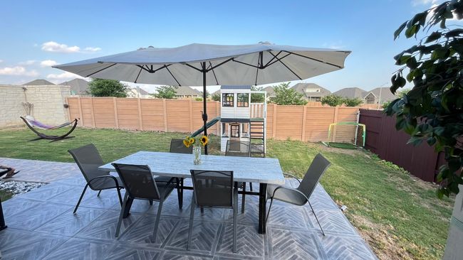 View of patio with outdoor dining space and a playground | Image 35