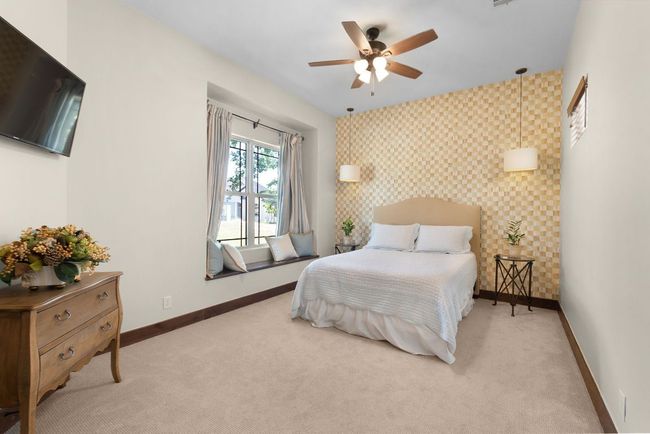 Guest bedroom featuring an accent wall, carpet flooring, wallpapered walls, and ceiling fan | Image 18