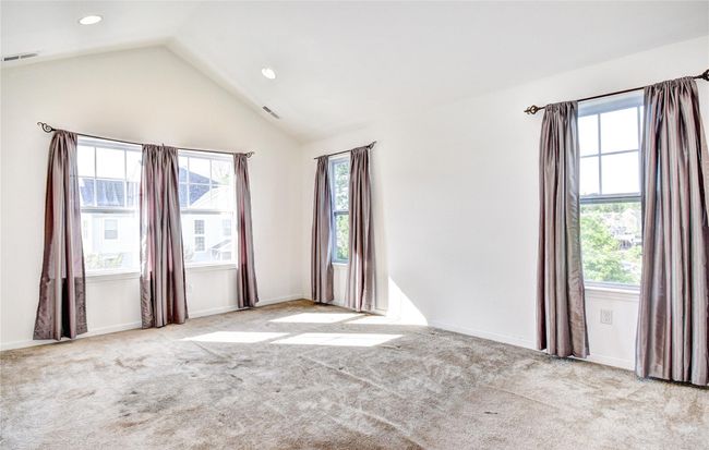 Primary bedroom featuring healthy amount of natural light, lofted ceiling, recessed lighting, carpet | Image 14