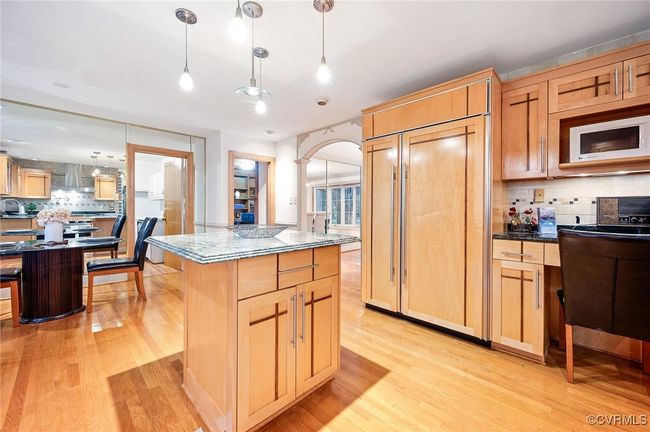 Cook like a pro in this 14' x 13' space with a WOLF 6-burner range, pot filler, and paneled Sub-Zero fridge—all wrapped in timeless tilework and warm wood cabinetry. | Image 6