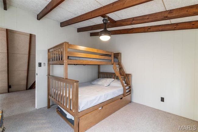 Carpeted bedroom featuring beamed ceiling | Image 36