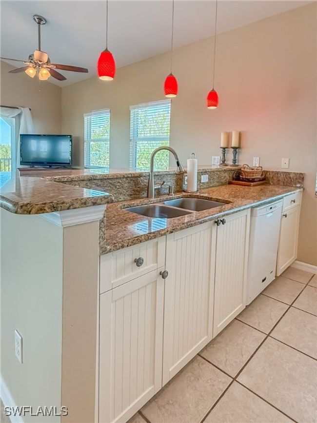 Kitchen featuring a peninsula, plenty of natural light, white dishwasher, and a sink | Image 15