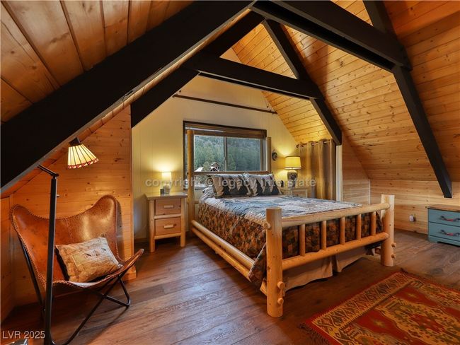 Bedroom with wooden ceiling, wood walls, lofted ceiling with beams, and hardwood / wood-style flooring | Image 26