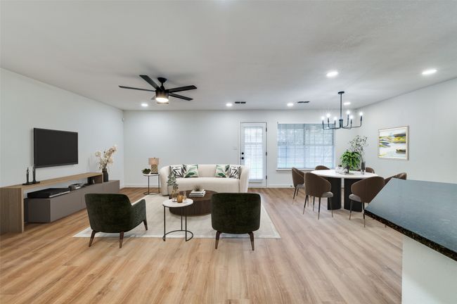 Living room featuring baseboards, light wood-type flooring, recessed lighting, and ceiling fan with notable chandelier | Image 7