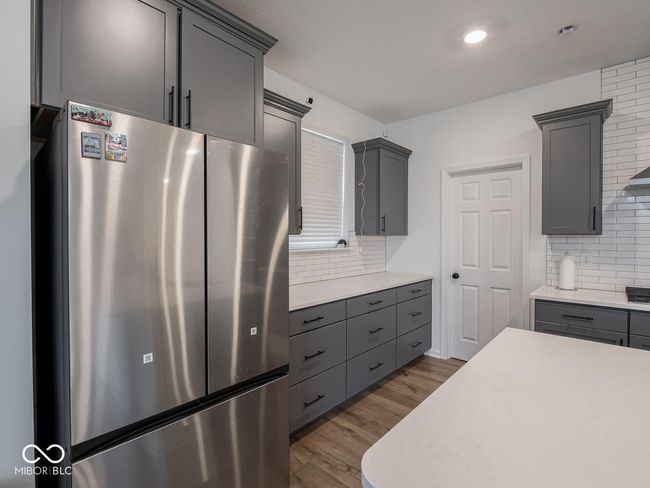 kitchen featuring gray cabinets, light countertops, freestanding refrigerator, and wood finished floors | Image 19