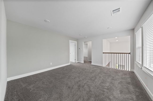 Spacious second-floor game room with a stunning overlook of the entryway and living room below. | Image 13
