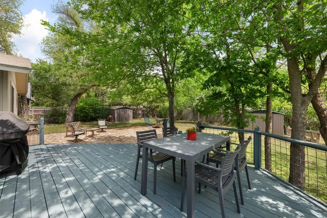 Deck featuring outdoor dining area, an outdoor structure, a fenced backyard, and a storage unit | Image 22